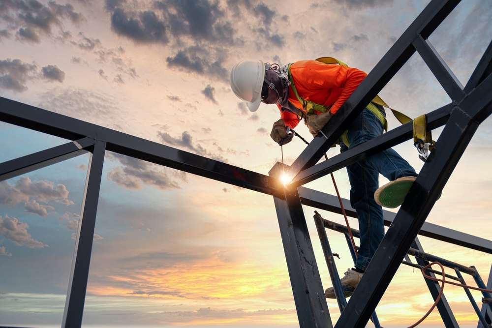 welder standing on construction site high up
